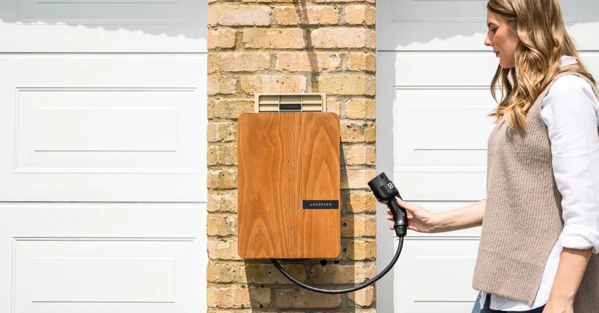 Houten wallbox met laadkabel aan een bakstenen gevel